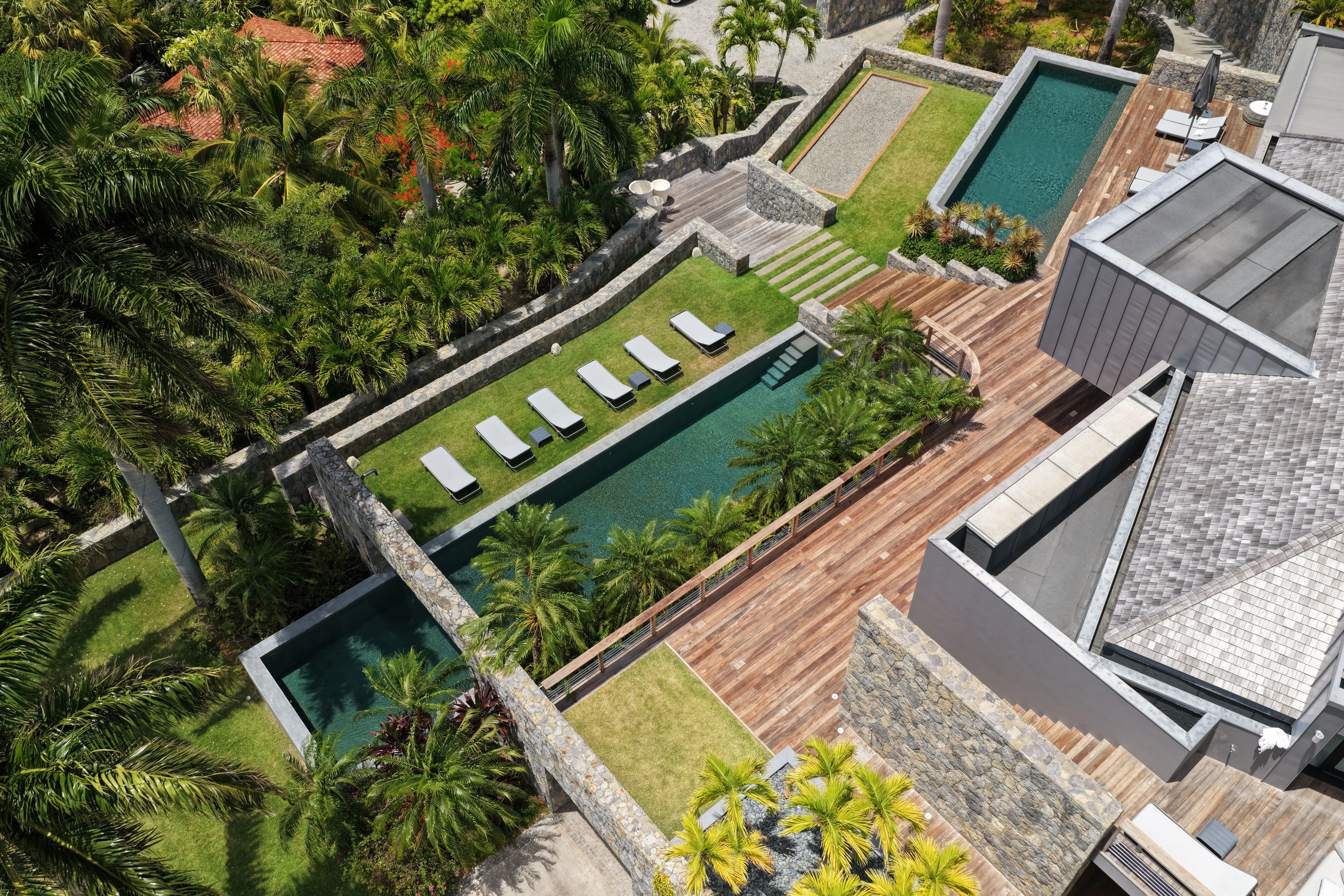 The two pools, the loungers on the lawn, the petanque court and the decks, from straight above