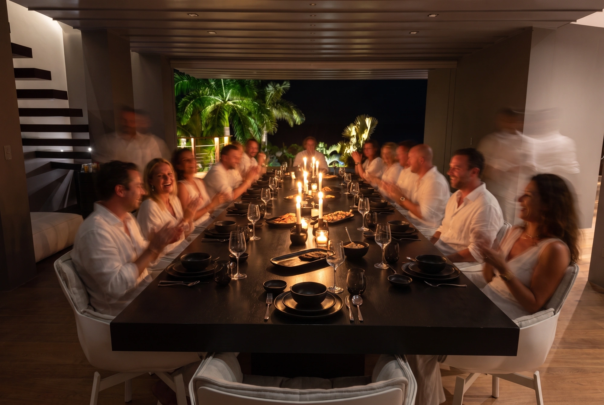 A long table at dinner, candles down its length