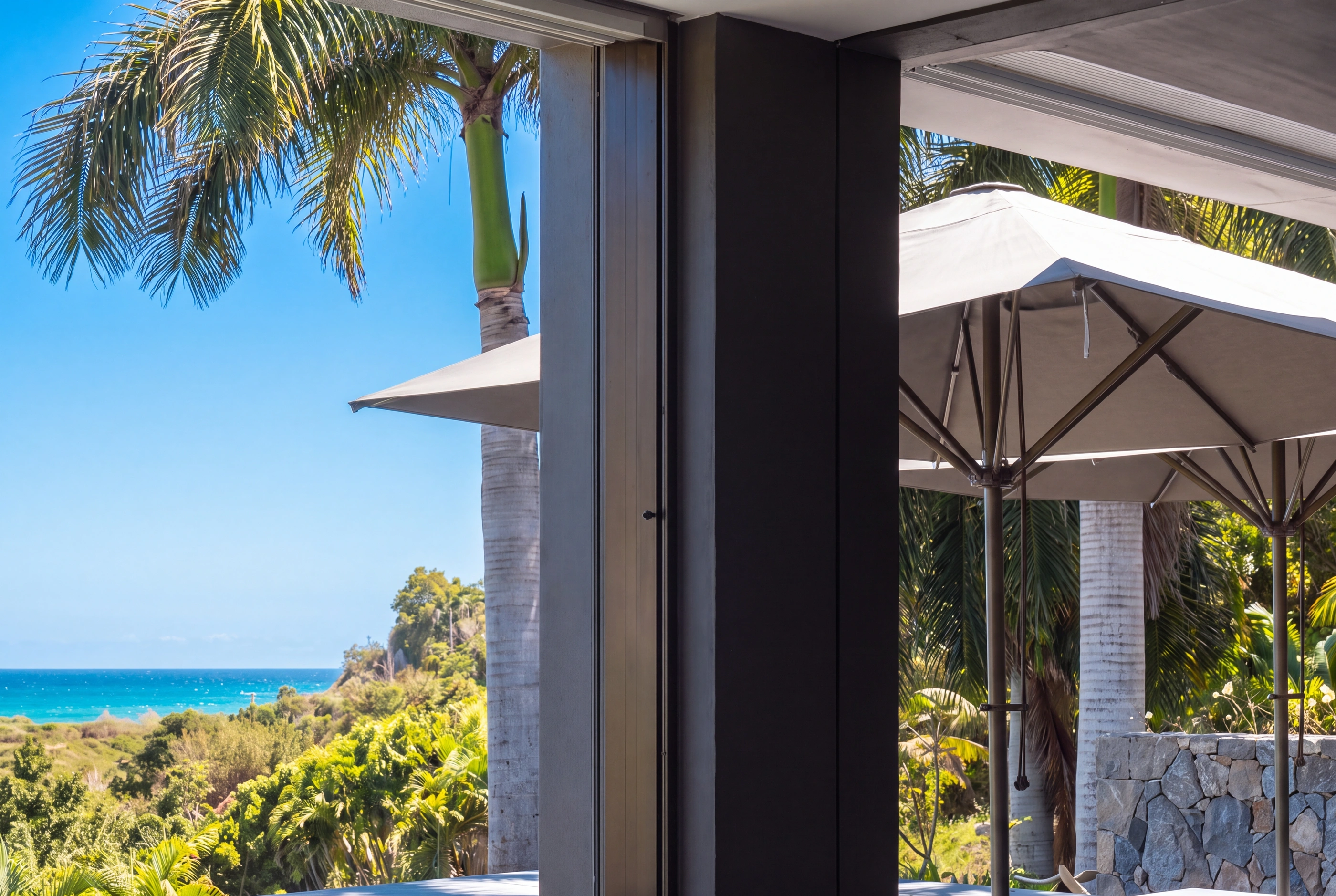 A parasol, palms and the sea