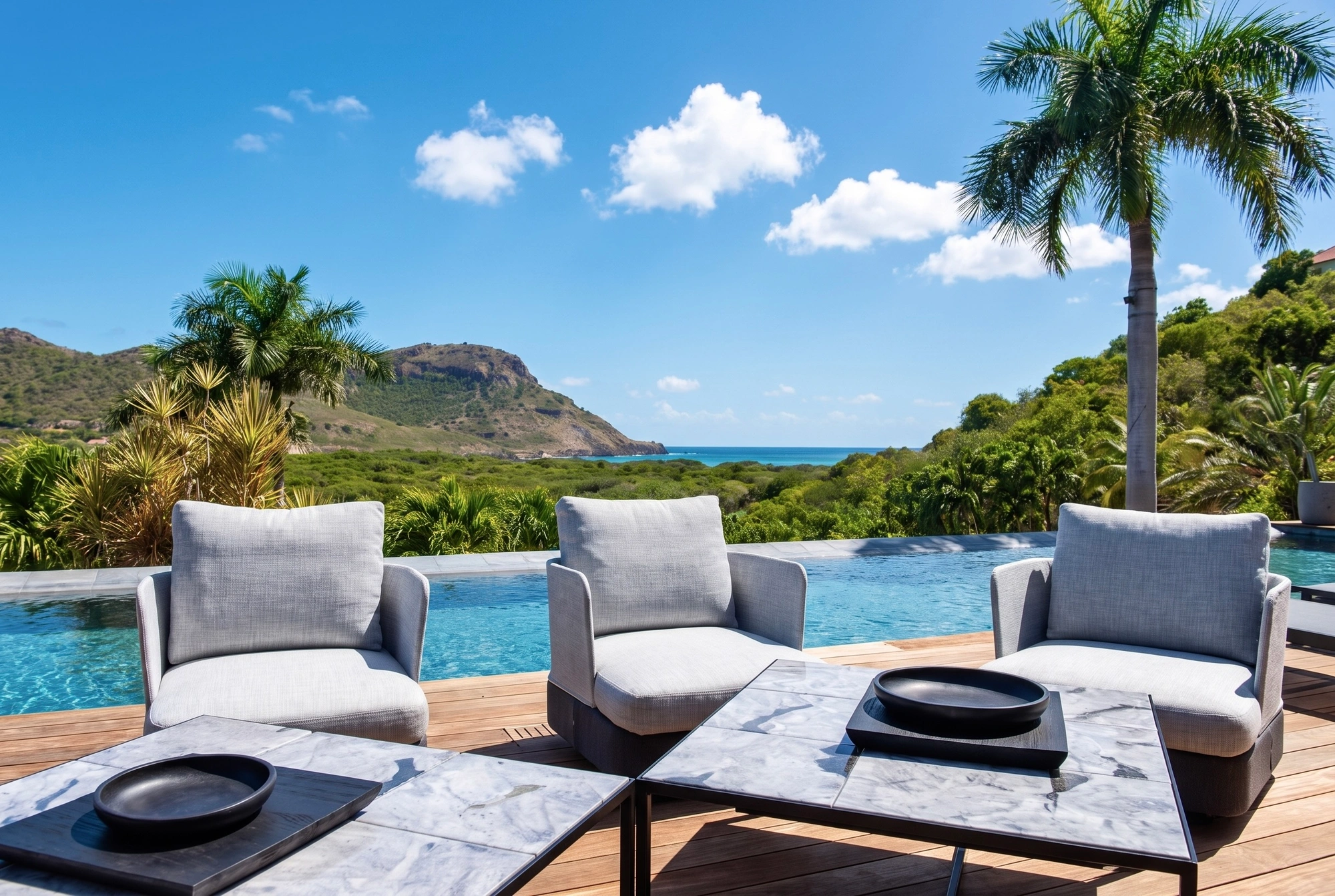 Three armchairs on the pool deck, the hills and the bay beyond