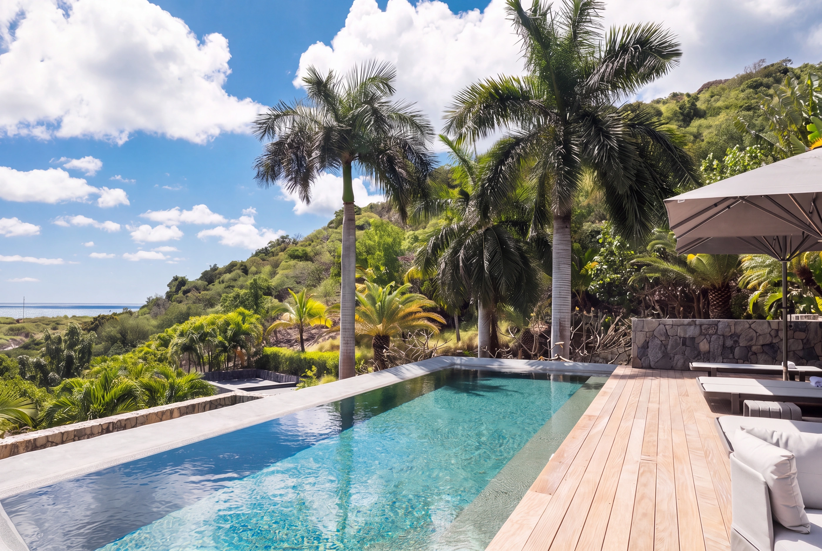 The pool deck under the palms, the sea beyond
